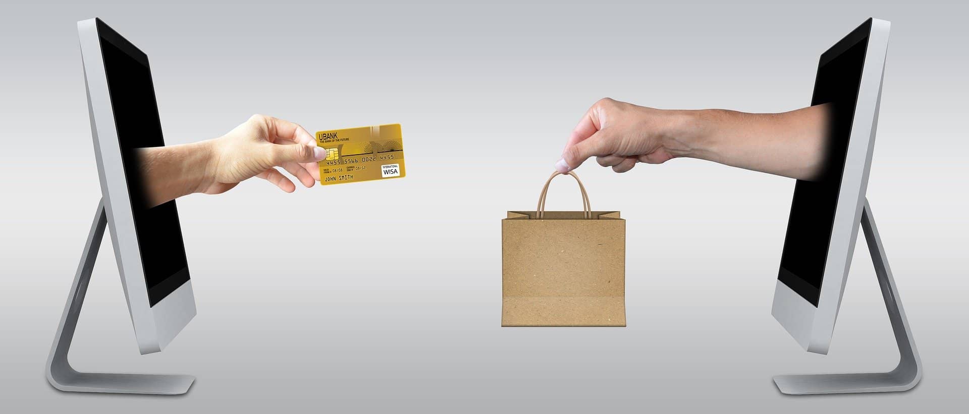 Image représentant 2 ordinateurs portables s'échangeant un produit et une carte bancaire